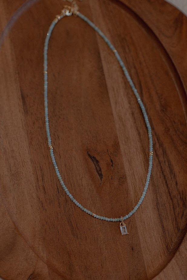 Necklace with a small pendant on a wooden surface