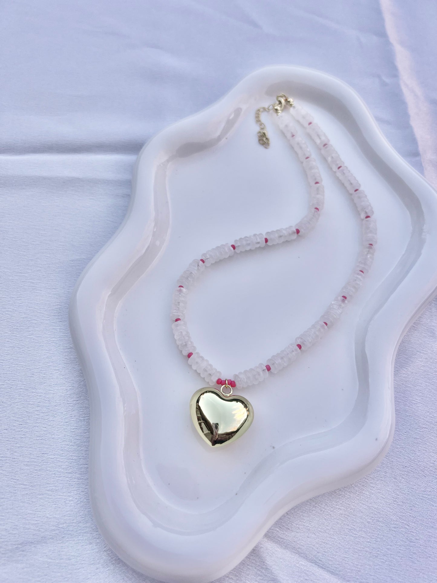 Necklace with a heart-shaped pendant on a white dish