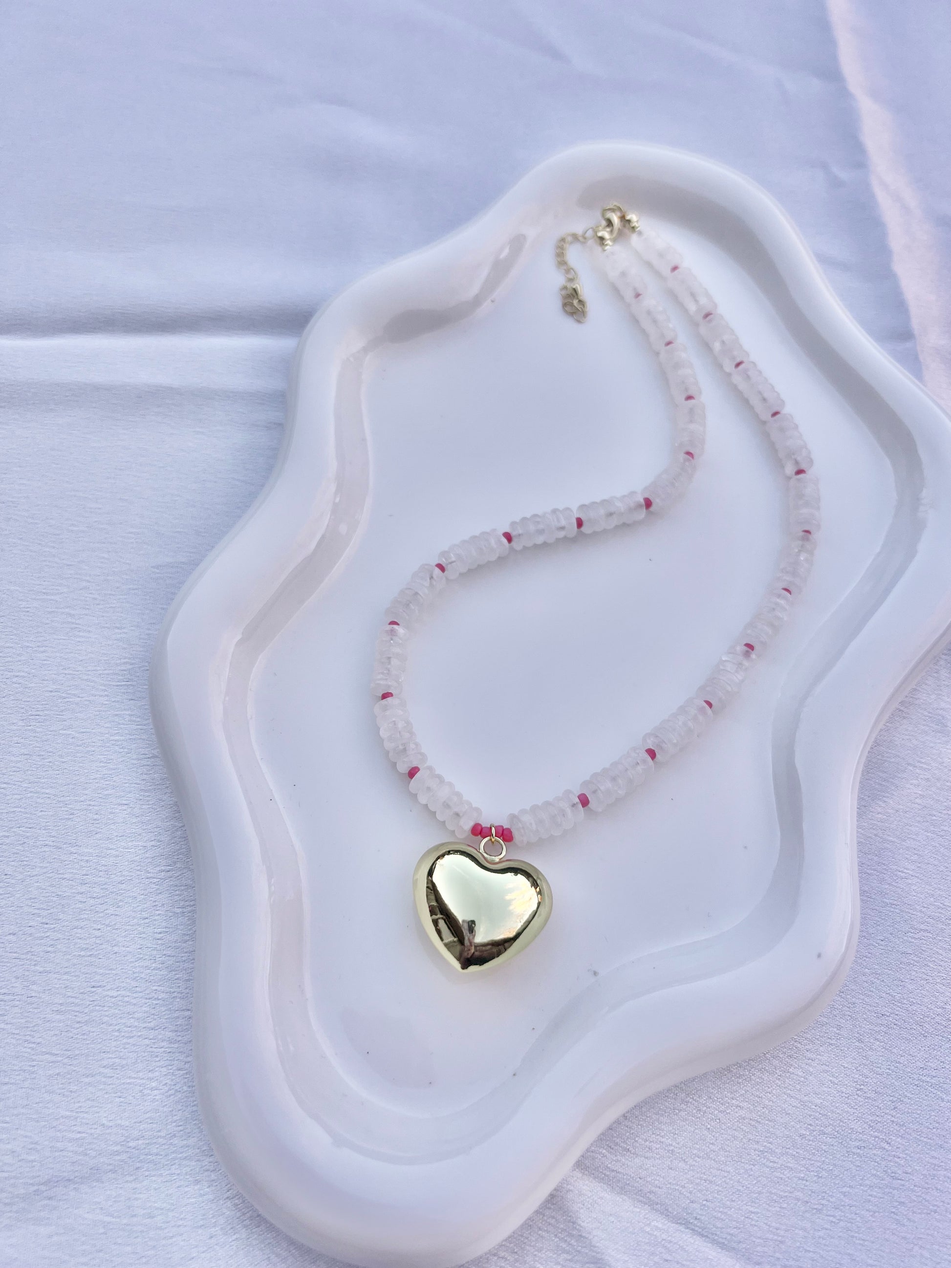 Necklace with a heart-shaped pendant on a white dish