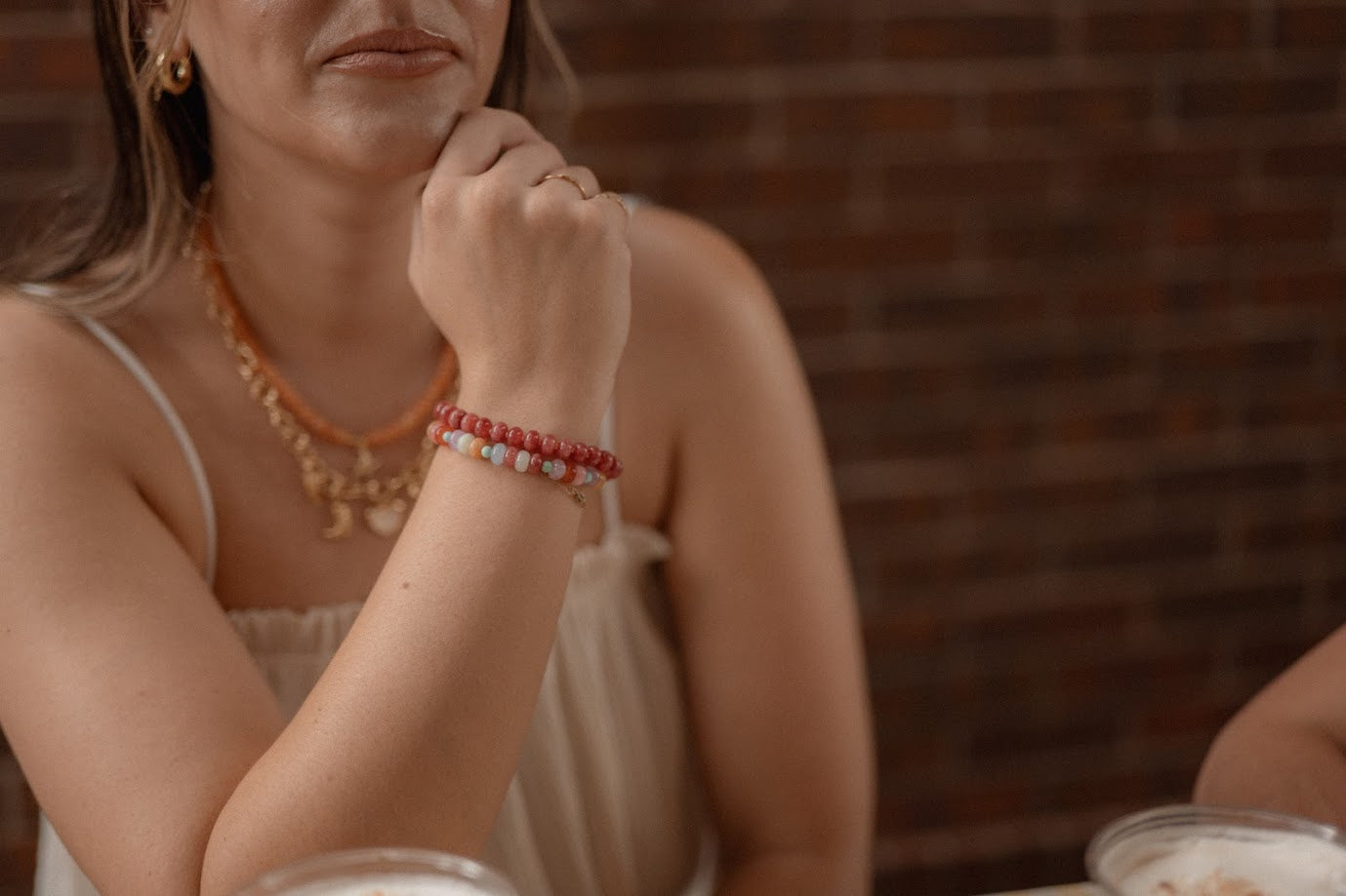 Woman wearing a necklace and bracelets with a blurred background