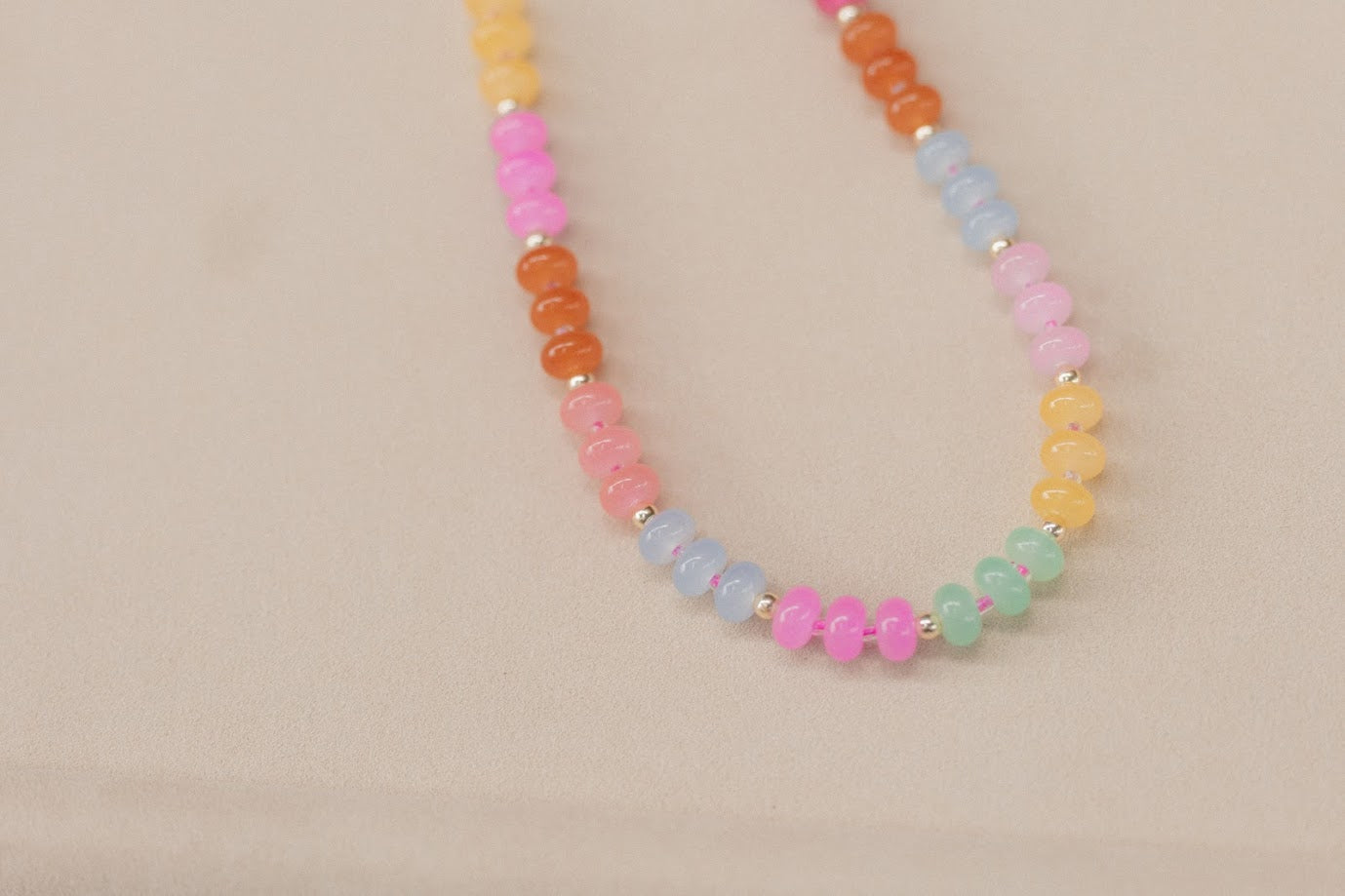 Necklace with multicolored beads on a beige background