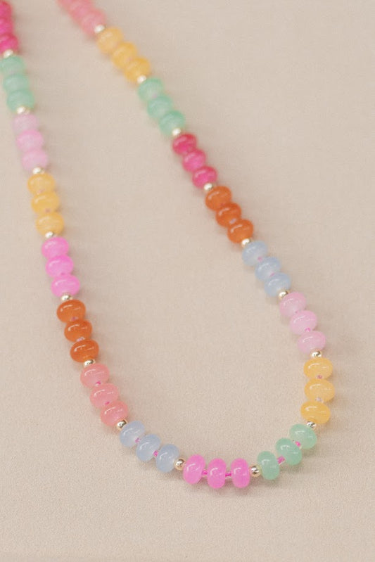 Necklace with multicolored beads on a beige background