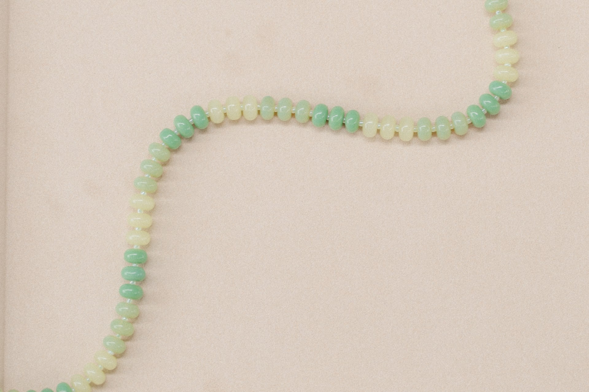 Necklace with green beads on a beige background