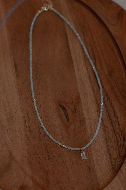 Necklace with a small pendant on a wooden surface